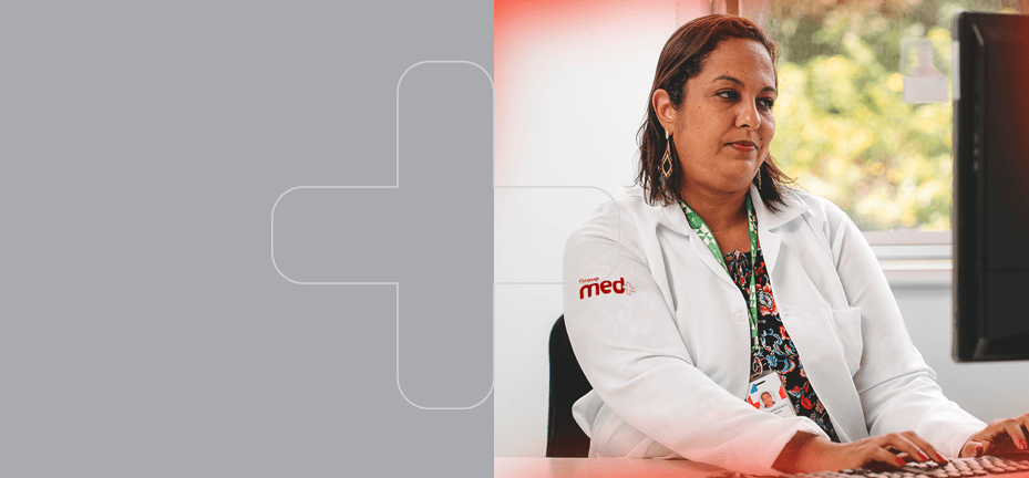 Banner med member em medicina ocupacional trabalhando no computador.